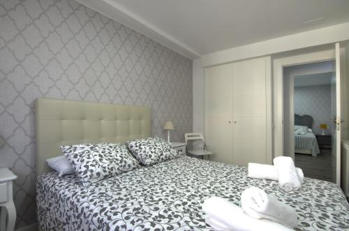 1 dormitorio con 1 cama con sábanas y almohadas blancas en Apartment Ronda Sant Antoni, en Girona