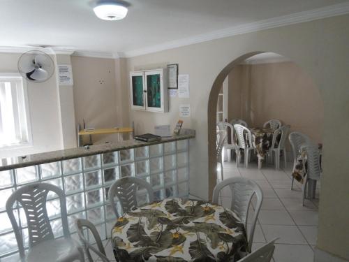 a restaurant with a table and chairs in a room at Pousada Gran Gaviota in Cabo Frio