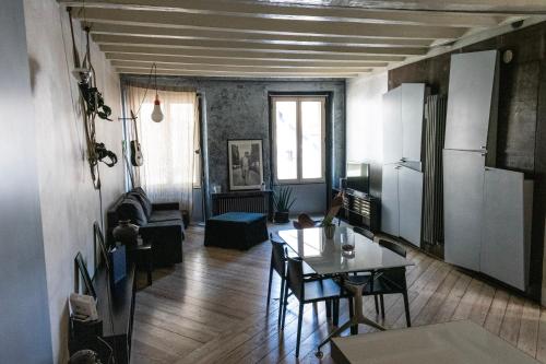 ベルガモにあるFlora Inn, Flora I - Nel cuore di Bergamo Altaのテーブルとキッチンのあるリビングルーム