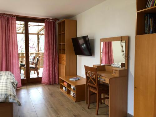 una camera con scrivania e computer con tende rosa di Apartments Kamp Podgrad Vransko a Vransko