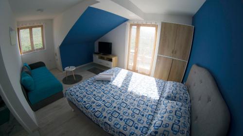a blue bedroom with a bed and a blue wall at Apartments Ena in Trebinje