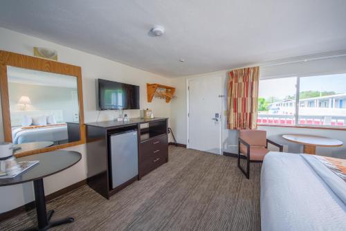 a hotel room with a bed and a table and chairs at Cape Sands Inn in West Yarmouth