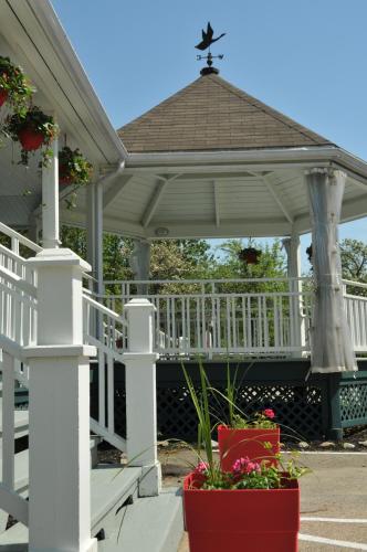 a white gazebo with flowers in a pot at Auberge Beausejour in Les Éboulements