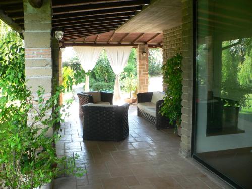 a patio with two couches on a brick wall at Villa con piscina in Canale Monterano