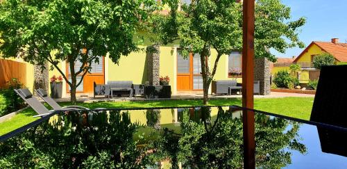 a backyard with a pool with chairs and trees at Třeboňské Apartmány in Třeboň