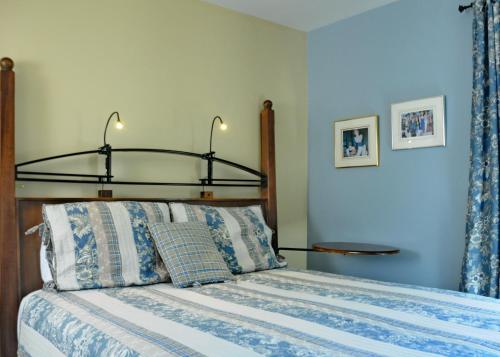 a bedroom with a bed with a wooden headboard at Auberge Beausejour in Les Éboulements
