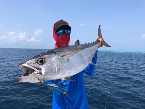 a man holding a fish on a fishing pole at Faima Fishing Lodge at Daravandhoo in Baa Atoll