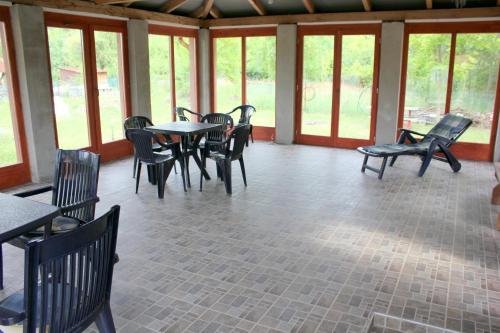 a dining room with tables and chairs and windows at Számadó Vendégház in Poroszló