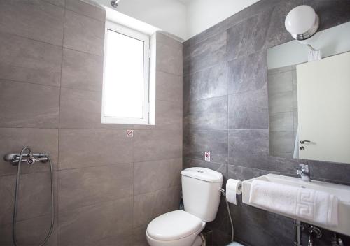 a bathroom with a toilet and a sink and a mirror at Snooze H in Athens