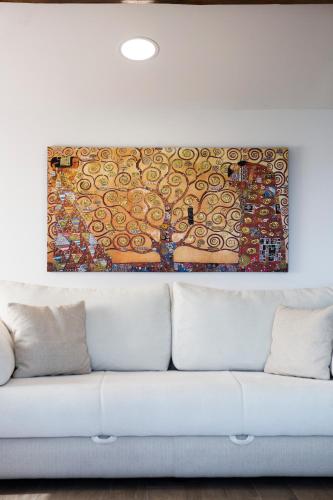 a painting on the wall above a white couch at Red Rose Apartment in Portorož