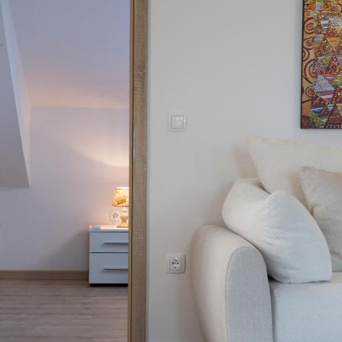 a living room with a white couch and a table at Red Rose Apartment in Portorož