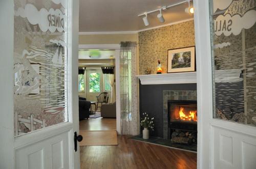 a living room with a fireplace and a fire place at Auberge Beausejour in Les Éboulements