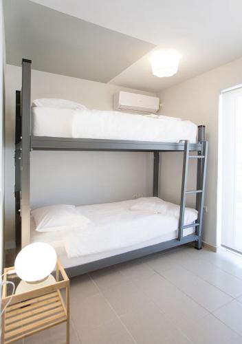 two bunk beds in a room with a table at Snooze H in Athens
