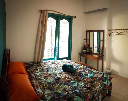 a bedroom with a bed with a quilt on it at L'isola che... in Karimunjawa