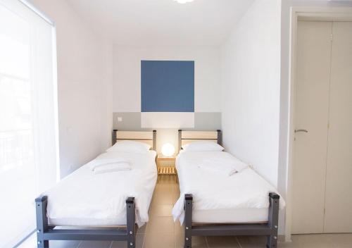 two beds in a room with white walls at Snooze H in Athens