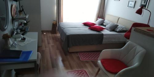 um quarto com uma cama com almofadas vermelhas em Klara Studio Apartman em Split