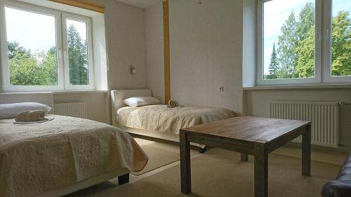 a room with two beds and a table and two windows at Observatory apartement in Tyravere