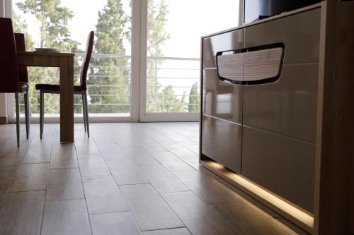 a kitchen with a refrigerator and a table and a window at Red Rose Apartment in Portorož