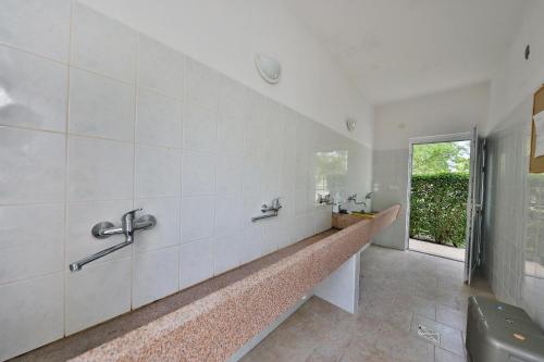 a bathroom with a long counter with a window at Mobile Home Grbe in Nin