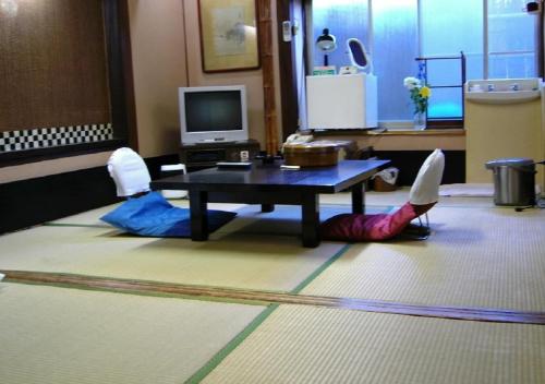 two people laying on the floor in front of a table at Komecho Ryokan / Vacation STAY 36247 in Imabari