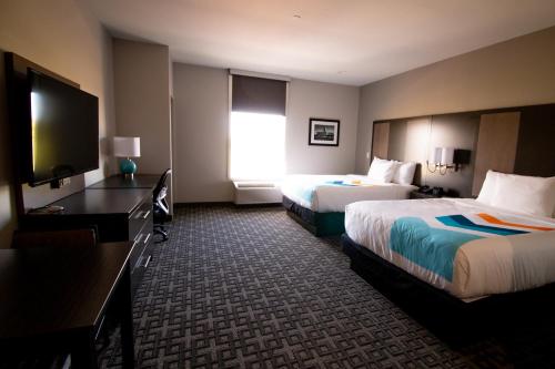 a hotel room with two beds and a flat screen tv at HOTEL PRYOR in Pryor