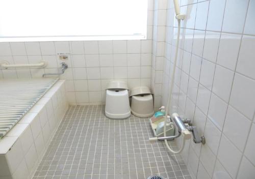 bagno con 2 servizi igienici in una camera piastrellata di Komecho Ryokan / Vacation STAY 36247 a Imabari