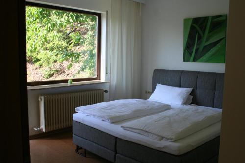 a bed in a room with a large window at Maison au soleil in Egloffstein