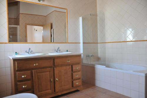 een badkamer met een bad, een wastafel en een bad bij Casa do Cabeco in Seia