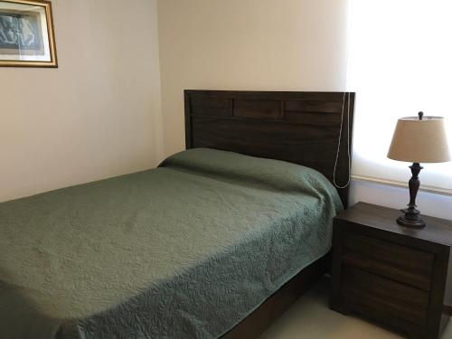1 dormitorio con 1 cama y 1 mesa con lámpara en Jaco Beach Penthouse, en Jacó