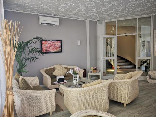 - un salon avec des chaises en osier et une table dans l'établissement Hotel My Fair, à Lido di Jesolo