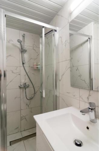 a bathroom with a shower and a white sink at Larnaka Seaview Luxury Suites in Larnaca