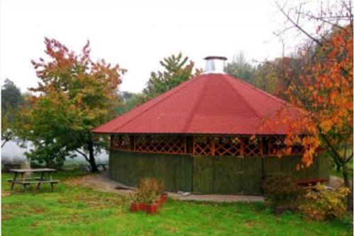 a gazebo with a red roof in a park at Motel u Olka Boczów in Boczów