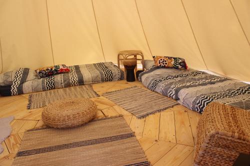 a room with mats and rugs in a tent at Insolites en Mené in Saint-Vran