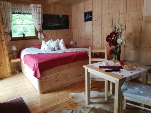 ein Schlafzimmer mit einem großen Bett und einem Tisch in der Unterkunft Ferienhaus Barbara in Ebenthal