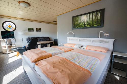 a bedroom with two beds and a desk at Café und Pension Theodor Fontane in Altenbrak