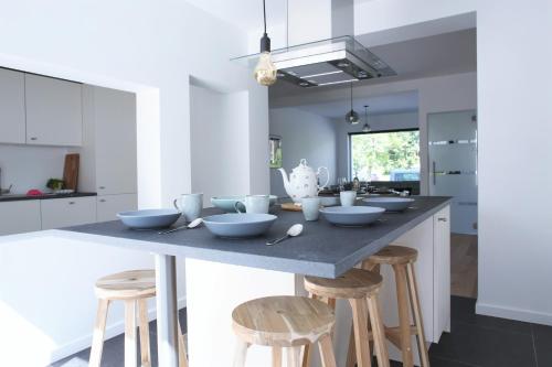 a kitchen with a large island with stools at Brygga in Bruges