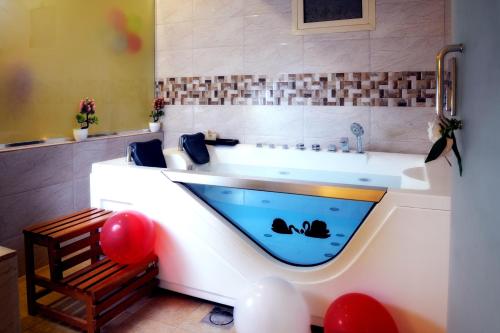 a bathroom with a tub with a swimming pool at Garden Plaza Hotel in Al Hofuf