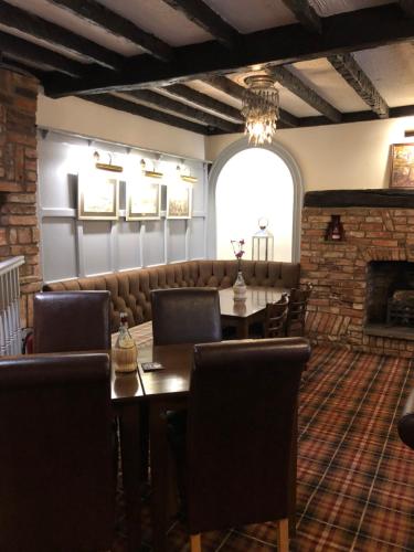 a dining room with a table and chairs and a fireplace at The Brewers Arms in Snaith