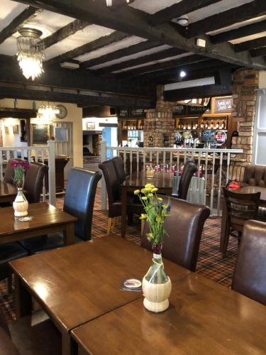 a restaurant with wooden tables and chairs with flowers on them at The Brewers Arms in Snaith