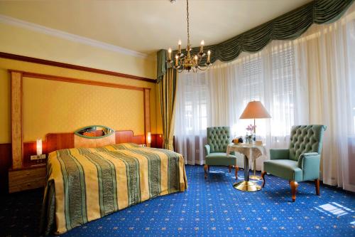 a hotel room with a bed and a table and chairs at Häcker's Hotel in Bad Ems