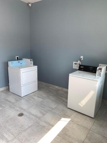 a room with two white refrigerators and a wall at Scottish Inns and Suites Scarsdale in Houston