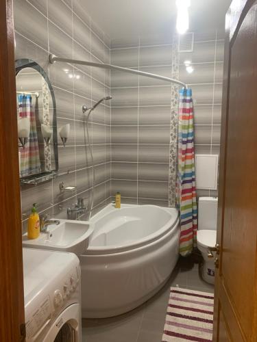 ein Badezimmer mit einer Badewanne, einem Waschbecken und einem WC in der Unterkunft Александра Поля проспект Апартаменты in Dnipro