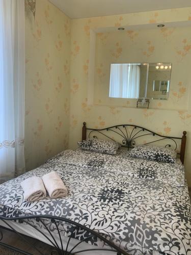 Schlafzimmer mit einem schwarzen und weißen Bett und einem Spiegel in der Unterkunft Александра Поля проспект Апартаменты in Dnipro