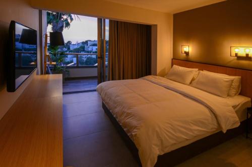 a bedroom with a large bed and a balcony at Luxury Suites by Notaly Ariel in Haifa