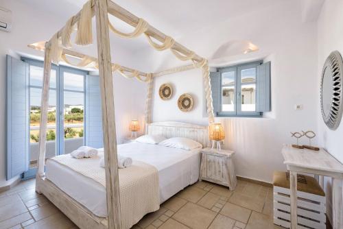 a bedroom with a four poster bed and a window at Villa Vanta in Drios
