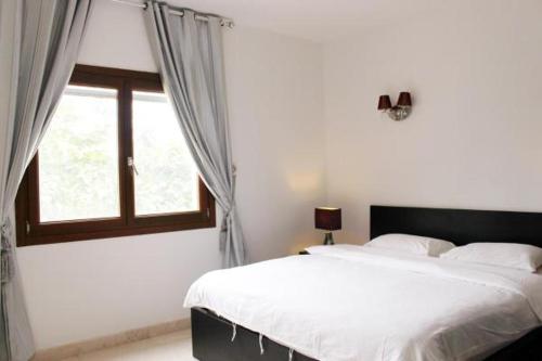 - une chambre avec un grand lit et une fenêtre dans l'établissement NOOR PLAZA BEACH FURNISHED FLATS, à Salalah