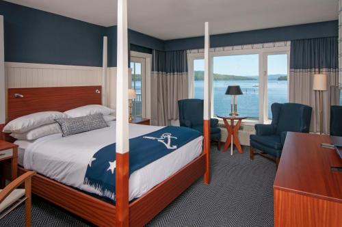 a hotel room with a bed and a desk and chairs at Mill Falls Resort Collection at the Lake in Meredith