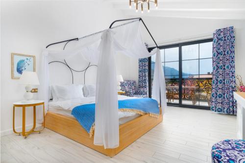 a bedroom with a canopy bed and a large window at Hotel Karbel Sun in Oludeniz