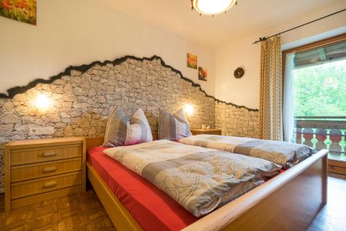 two beds in a bedroom with a stone wall at Ferienhof Alfred Albrecht in Oberstdorf