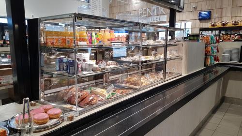 een vitrine in een bakkerij met veel verschillende voedingsmiddelen bij Hotelli Kärsämäki in Kärsämäki